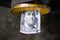 Benjamin Franklin on a 100 dollar bill rolled into a tube. Money in an industrial mechanism. Yellow metal part