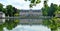 Benrath pink palace and green trees are reflected on the mirror-like surface of the lake, Dusseldorf, Germany.