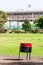 Bent black red waste container standing in Jerusalem park in front of Knesset that is the unicameral national legislature of