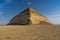 Bent Pyramid is an ancient Egyptian pyramid, the first, located at the royal necropolis of Dahshur outside of Cairo Egypt