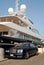 Bentley parked in front of a luxury yacht
