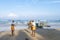 BENTOTA, SRI LANKA - NOVEMBER 14, 2019: Fishermen sort through nets next to a wooden boat on the Indian ocean shore