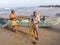 BENTOTA, SRI LANKA - NOVEMBER 14, 2019: Fishermen sort through nets next to a wooden boat on the Indian ocean shore