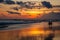 Berawa beach Pantai Berawa at sunset. Silhouettes of two people sitting in the tide. Canggu, Bali, Indonesia.