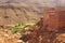 Berber village in valley surrounded by rugged high mountain walls with old brick clay houses