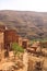 Berber village in valley surrounded by rugged high mountain walls with old brick clay houses