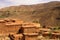Berber village in valley surrounded by rugged high mountain walls with old brick clay houses