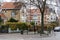 Berchem-Sainte-Agathe, Brussels Capital Region, Belgium - Small residential square with a bench, houses and a tree