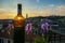 Bergamo - Bottle of wine with scenic sunset view of tower of  church Chiesa di Sant Alessandro della Croce