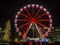 Bergamo, Italy. The Ferris wheel illuminated in red in the evening. Christmas time. Fun attraction