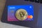 Berlin, Germany - April 21, 2021: Revolut Mastercard and a bitcoin currency lying on laptop.Revolut is a fast, simple, and easy