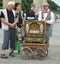 Berlin, Germany - July 2015 - Barrel organ player with elderly tourist couple