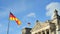 BERLIN GERMANY MAY 26 2017 German flags fluttering in the wind and building of Reichstagin on blue sky background