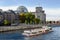 BERLIN, GERMANY - Oct 14, 2013: Side view of the stunning Reichstag building, tourist ferry navigates along the river Spree