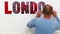 BERLIN, GERMANY - OCTOBER 24, 2015: Young man decoring his white room wall with LONDON word on 24 October 2015 in BERLIN,GERMANY