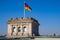 Berlin, Germany - Rooftop of the Reichstag building with the historic corner tower and Germany flag with Berlin skyline in