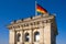 Berlin, Germany - Rooftop of the Reichstag building with the historic corner tower and Germany flag with Berlin skyline in