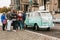 Berlin, October 1, 2017: Group of young unknown tourists book tourist trip on blue retro mini bus next to the Berlin