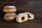 Berliner donuts or Krapfen filled with red jam, traditional sweet pastry for carnival and New Year, dark brown rustic wood, copy