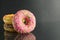 Berliner doughnuts with icing pink yellow lie stops and pink bright stands on a black background with room for text