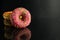 Berliner doughnuts with icing pink yellow lie stops and pink bright stands on a black background with room for text