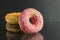 Berliner doughnuts with icing pink yellow lie stops and pink bright stands on a black background with room for text