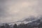 Bernese Alps Mountains covered in mist under grey sky