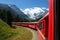 The Bernina Express train of the Rhaetian Railway, with the Morteratsch glacier in the background, Switzer