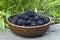 Berries of blackberries in clay pots against the background of fresh greens