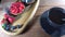 Berries are poured on a wooden plate with a dessert, the waiter serves dessert