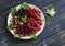 Berries - raspberries, gooseberries, red currants, cherries, black currants on a white plate