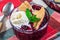 Berry cobbler in glass ramekin with ice cream, horizontal, closeup