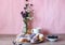 Berry glazed eclairs with blueberries on a wooden background with a decor consisting of a vase with wildflowers and a