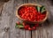 Berry goji with leaves in wooden bowl