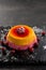 Berry orange pudding on stone plate with cranberry on black background