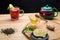 Berry tea in a cup next to lemon, honey, lemon balm and a teapot with a drink on the table.