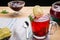 Berry tea in a cup next to a teapot spoon and jam lemon and lemon balm on a napkin top view.