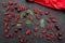 Berry theme. Red currant, cherry and leaves on black table background top view