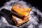 Besquit, cake on a black background, sprinkled with powdered sugar, dark and light layer of beckett on a black background, copy