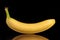 The best banana on a black background with reflection, closeup. Minimalist design for poster, cover, branding, banner, placard.