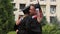 Best friends in academic dresses and hats hugging and smiling on graduation day