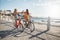 Best friends riding cycles on the seaside promenade