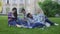 Best friends spending time together sitting on grass in university garden