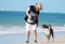 Best friends-Woman & pet dog walking on beach