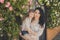 Best girlfriends adorable mother with dark black hairs and cute baby daughter with blond hairs and pink cheeks posing sit for toge