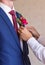 Best Man Adjusting Groom\'s Boutonniere close-up