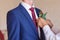 Best Man Adjusting Groom\'s Boutonniere close-up