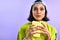 The best movies make you forget about your snacks. Studio shot of a beautiful young woman eating popcorn against a