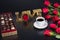 Best valentines presents, red roses and a box of chocolate candy next to a good cup of coffee