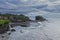 The best view of Tanah Lot Bali with lots of tourist surrounding and waves hitting the beach